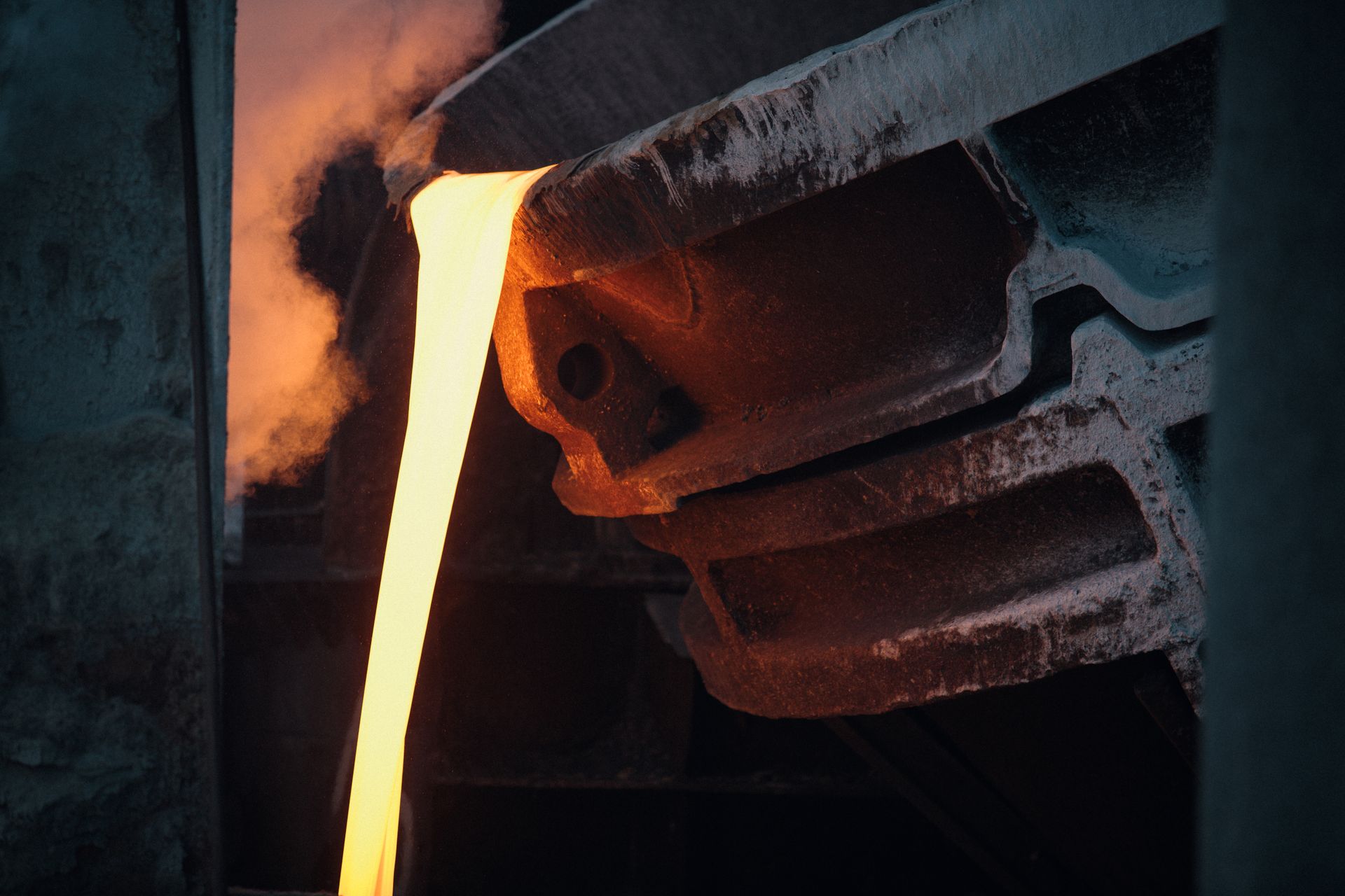Molten metal pouring from a ladle in a foundry